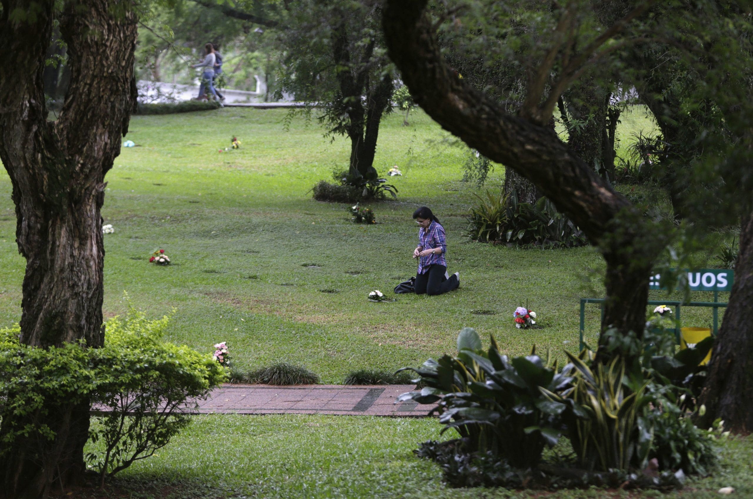 A woman prays at the grave of a relative at a cemetery during the observance of All Souls' Day in Asuncion, Paraguay, in this Nov. 2, 2014, file photo. With the continuing pandemic, the Vatican has again extended throughout all of November the opportunity to receive a plenary indulgence for visiting a cemetery to pray for the dead. (CNS photo/Jorge Adorno, Reuters)