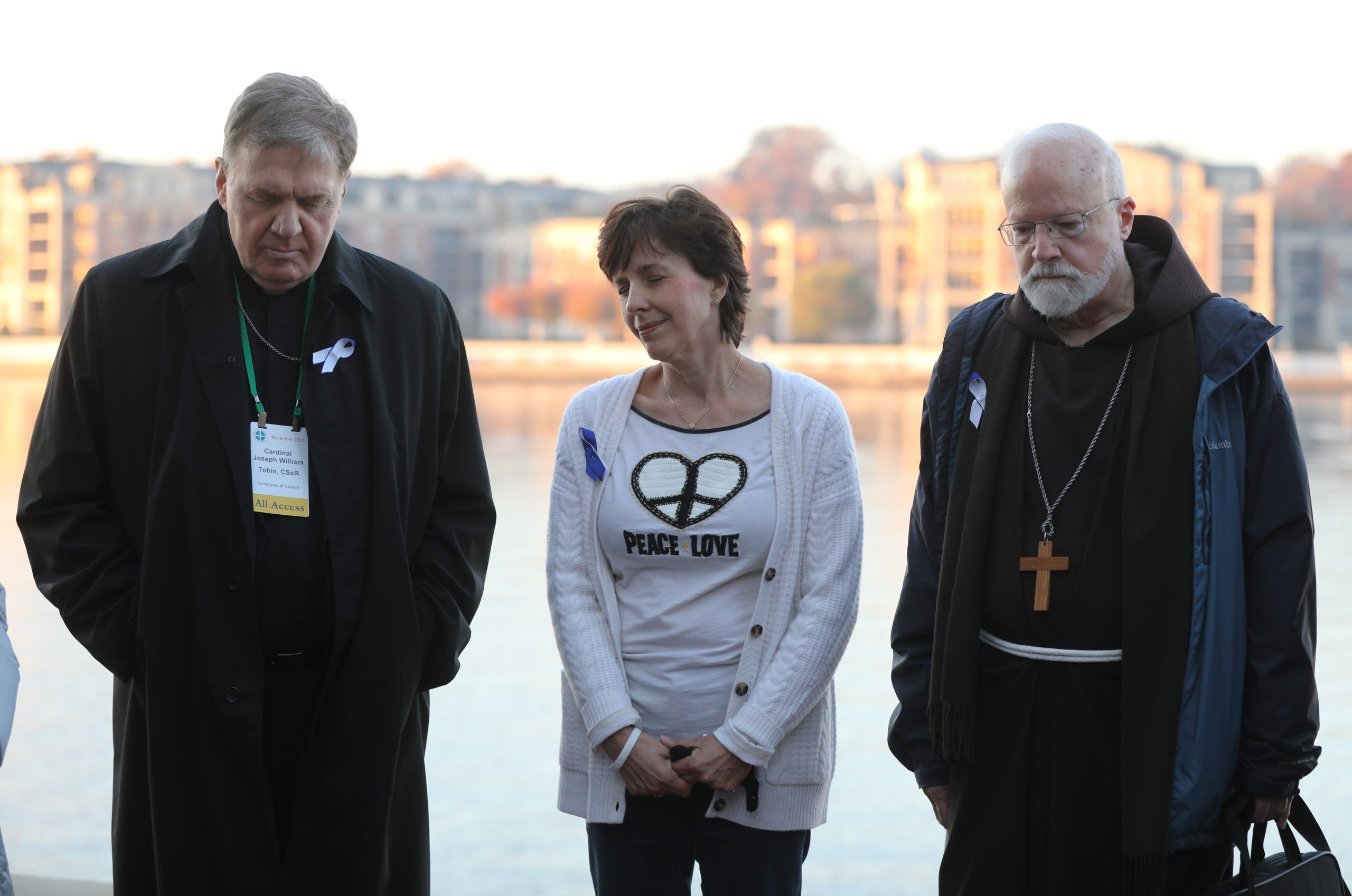 Cardinals Joseph W. Tobin of Newark, N.J., and Seán P. O'Malley of Boston, president of the Pontifical Commission for the Protection of Minors, pray alongside organizer Jennifer Wortham before a sunrise walk to end abuse Nov. 18, 2021, outside the hotel in Baltimore where the fall general assembly of the U.S. Conference of Catholic Bishops was held Nov. 15-18. (CNS photo/Bob Roller)