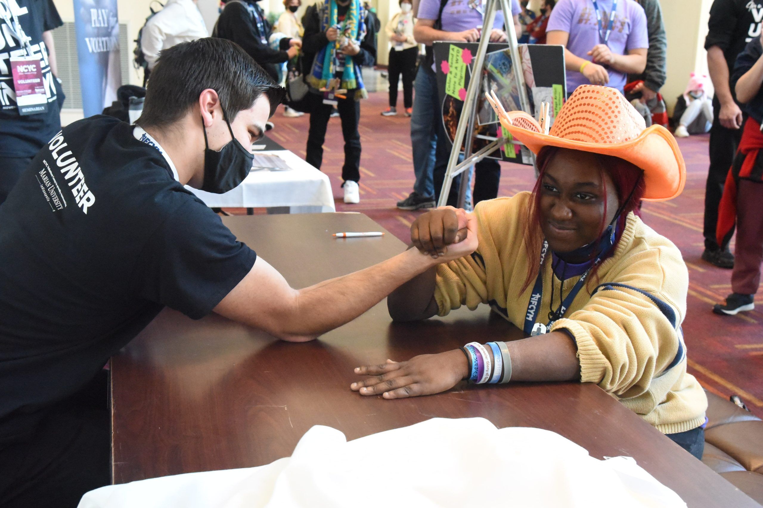 Alex Lindbergh, left, a freshman at Bishop Bruté College Seminary in Indianapolis, arm wrestles Asia Carmon of the Diocese of Raleigh, N.C., at the Indiana Convention Center in Indianapolis Nov. 20, 2021, during the National Catholic Youth Conference. (CNS photo/Sean Gallagher, The Criterion)