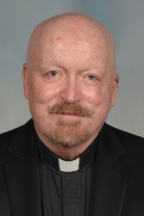 A headshot of Thomas J Mc Dade.