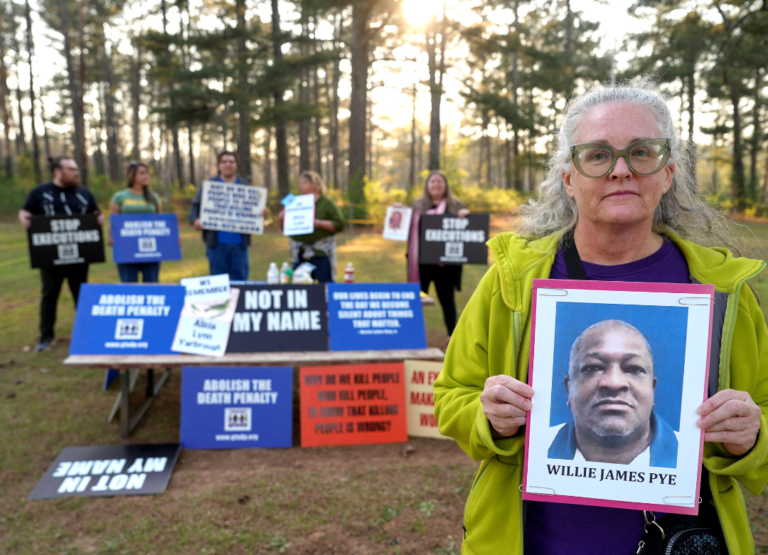 Cathy Harmon-Christian, the executive director of "Georgians for Alternatives to the Death Penalty," holds a photo of Willie James Pye outside of the Georgia Diagnostic Prison in Jackson, March 20, 2024. (OSV News photo/Jayla Whitfield-Anderson, Reuters)