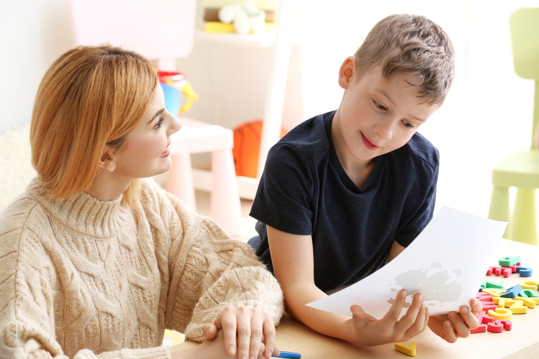Therapist working with boy with autism