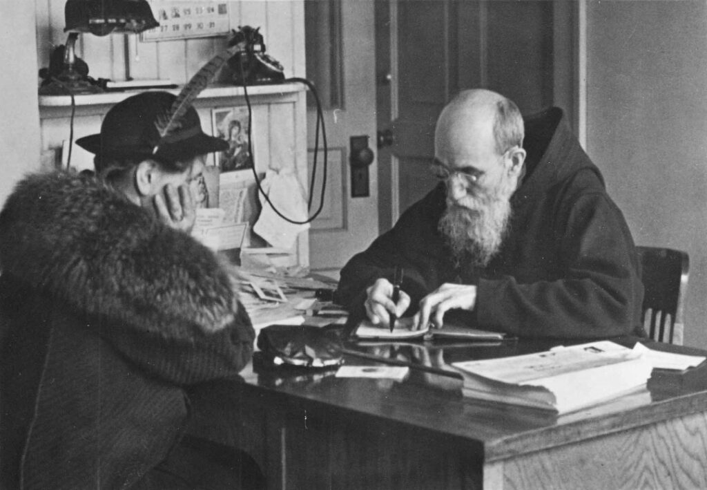 Blessed Solanus Casey listening and writing in notebook