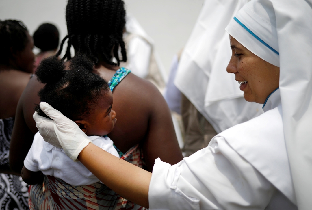 Missionary of Risen Christ comforts young migrant
