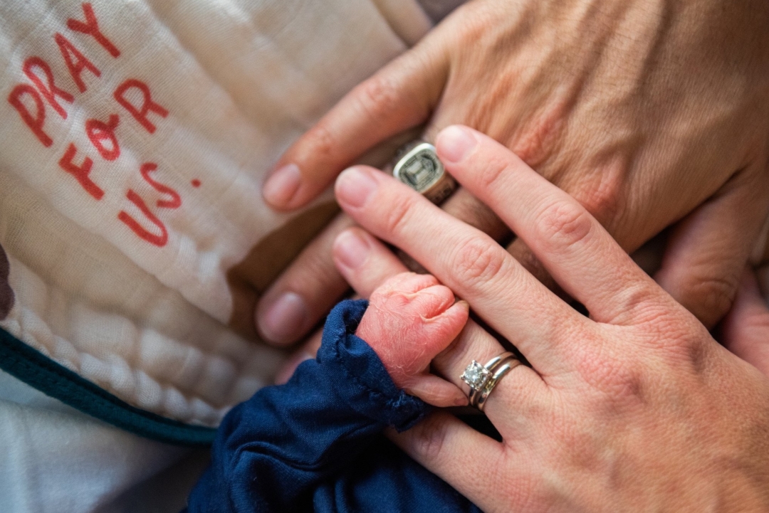 Close up baby and parents hands