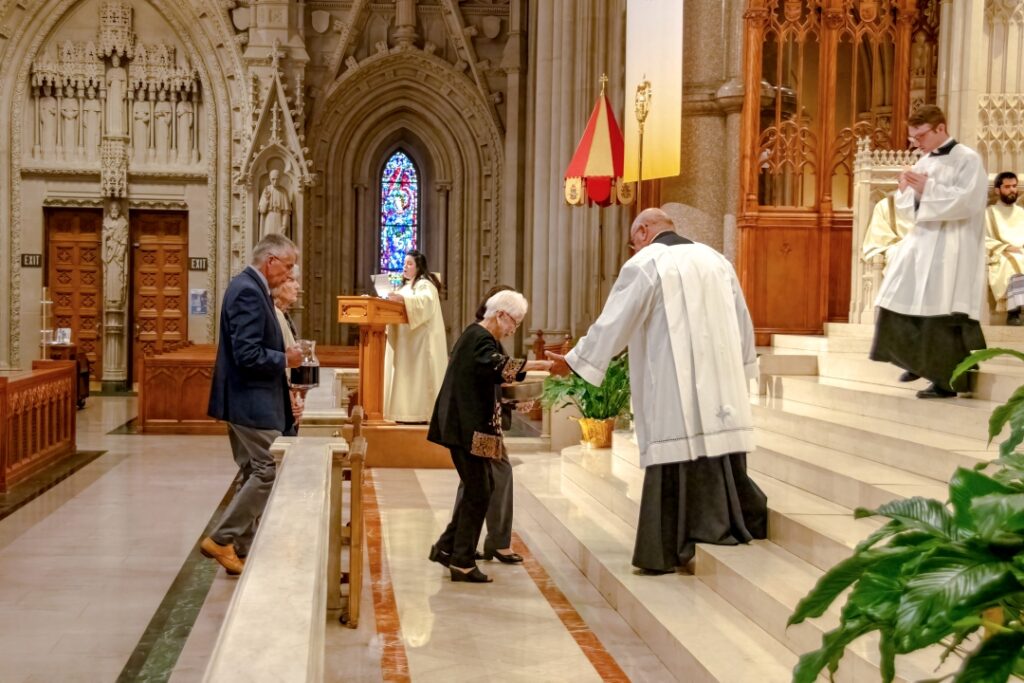 Mother of deceased clergy brings gifts to altar.