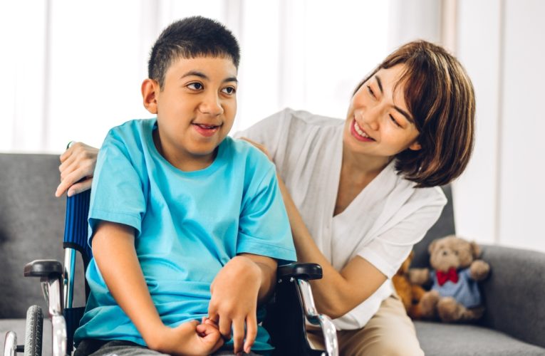 Woman caring for boy in wheelchair