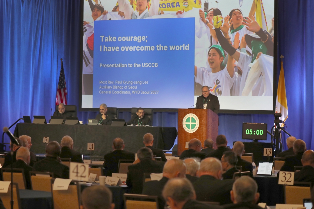 The U.S. bishops in a message to Pope Leo XIV June 10 thanked him for his new encyclical "Magnifica Humanitas" and for shining "the light of the Gospel and the tradition of the Church on the new opportunities and challenges posed by the rise" of artificial intelligence and "emerging technologies." The message to the pope about the first encyclical of his pontificate, which was released May 25 and addressed the rising era of AI and "new forms of dehumanization," was read aloud as the bishops opened the first of two public sessions during their spring plenary in Orlando. "You remind us that we must never lose sight of the life and dignity of the human person amid these profound developments," the bishops said in their letter. "May we never lose sight of the inherent dignity of all human life as we strive to ensure that technology serves the common good." Prayers for pope and for peace The bishops assured Pope Leo "of our prayers and our communion with you in the ministry of Peter." "As your papacy marks its first year, we pray that you continue to be a guiding light for the Church and for the world," they said. The U.S. bishops told the pope they joined him "in prayer for peace in our world as we continue to call for the defense of the most vulnerable, especially in areas of turmoil." "In this month of the Sacred Heart of Jesus, we humbly pray for the protection of all in harm's way," they continued, "and that through Jesus' perfect and overflowing love, there may be peace in Iran, Israel, Palestine, Lebanon, Ukraine, Myanmar, Sudan, Nigeria, and all the areas of the world torn by conflict and strife." Drawing ‘new maps of hope’ The bishops thanked Pope Leo for the teaching of his first encyclical letter. "At a time of rapid cultural and technological change, when the world is asking pertinent questions about the role and value of the human person ... you remind us that we must never lose sight of the life and dignity of the human person amid these profound developments," the bishops said. "May we never lose sight of the inherent dignity of all human life as we strive to ensure that technology serves the common good." The bishops pointed to the Church's "longstanding educational mission" as one example of those "areas for action" the pope wrote about in "Magnifica Humanitas," where each person in their own way "can cooperate in building the civilization of love." "In an age marked at times by fragmentation, isolation, and uncertainty among the young, the Church's educational tradition remains a vital model for authentic human formation," the bishops said in their message. "Your call to draw 'new maps of hope' inspires renewed efforts to accompany young people with confidence in the truth of the Gospel and with trust in their God-given dignity and vocation." They said that "as shepherds" of the U.S. Church, they are mindful "of the responsibility entrusted to us to strengthen the faith of our people, accompany those who are searching for meaning, and bear witness to the enduring truth of Christ in every aspect of society." Acknowledging challenges They acknowledged the challenges "that test our witness," including "the growing influence of secularism," the struggles families and young people have "to live the faith, "the need for renewed vocations, and the call to protect the dignity of every human life, from conception to natural death." The bishops' message to the pope also recalled their special pastoral message on immigration issued at their last fall general assembly, assuring Pope Leo that "we remain vigilant in calling our nation 'to recognize the fundamental dignity of all persons, including immigrants.'" Before the bishops' special message was approved Nov. 12, 2025, with 216 votes in favor of it, it was amended on the floor to clearly condemn "indiscriminate mass deportation" alongside their call to end "dehumanizing rhetoric and violence, whether directed at immigrants or at law enforcement." The bishops in Orlando told the pope that as they stated in that special pastoral statement, and "mindful of our nation's long history as a place of refuge and opportunity, we remain vigilant in calling our nation to recognize the fundamental dignity of all persons, including immigrants." "We bishops advocate for a meaningful reform of our nation's immigration laws and procedures. Human dignity and national security are not in conflict," they told the pope. "Both are possible if people of good will work together." Upcoming consecration "This week, as we consecrate the Church in the United States to the Sacred Heart of Jesus, we entrust our people, our families, and our communities to the Lord's abundant mercy and healing love," the bishops said. In anticipation of the 250th anniversary of the signing of the Declaration of Independence, the U.S. bishops will consecrate the country to the Sacred Heart of Jesus June 11 during their plenary. "In communion with Your Holiness, we pray that the Heart of Christ may renew the faith of our people, strengthen our charity, and make the Church ever more fully a sign of hope and unity in the world," they said, concluding the message. This article was written by OSV News staff. Featured image: Bishop Edward J. Burns of Dallas, chair of the U.S. Conference of Catholic Bishops' Committee on Laity, Marriage, Family Life and Youth, speaks about World Youth Day 2027 in Seoul, South Korea, during a June 10, 2026, session of the annual spring meeting of the U.S. Conference of Catholic Bishops in Orlando, Fla. (OSV News photo/Bob Roller)