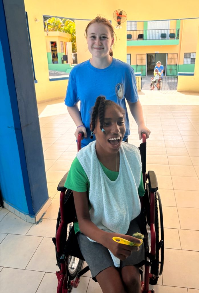 Ella with one of the many young people served by Mustard seed